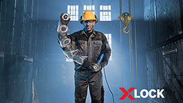 黄色のヘルメットをかぶった男性が作業場でボッシュX-LOCK工具を持っています.