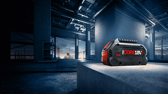 建設現場の灰色のコンクリートブロックの上にある黒いボッシュプロフェッショナルバッテリー。