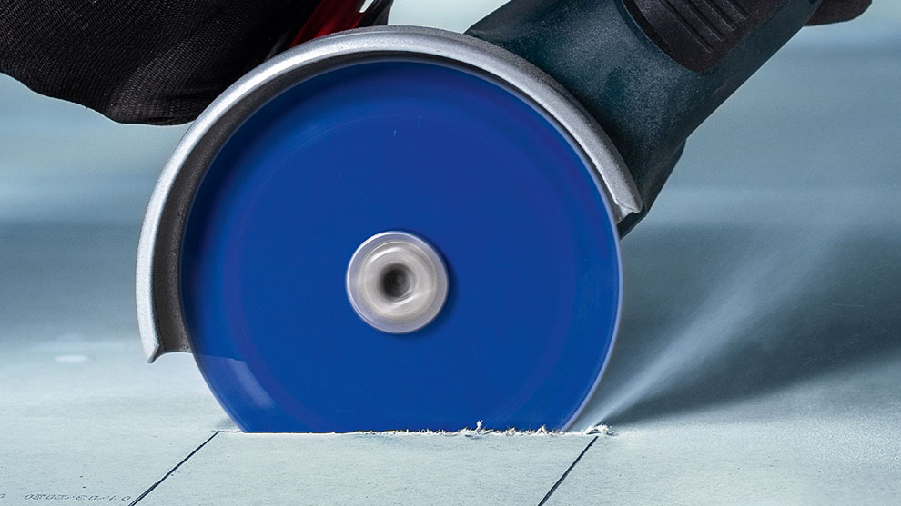 多材 青いボッシュプロフェッショナル切断ディスクが床材を切断しています。