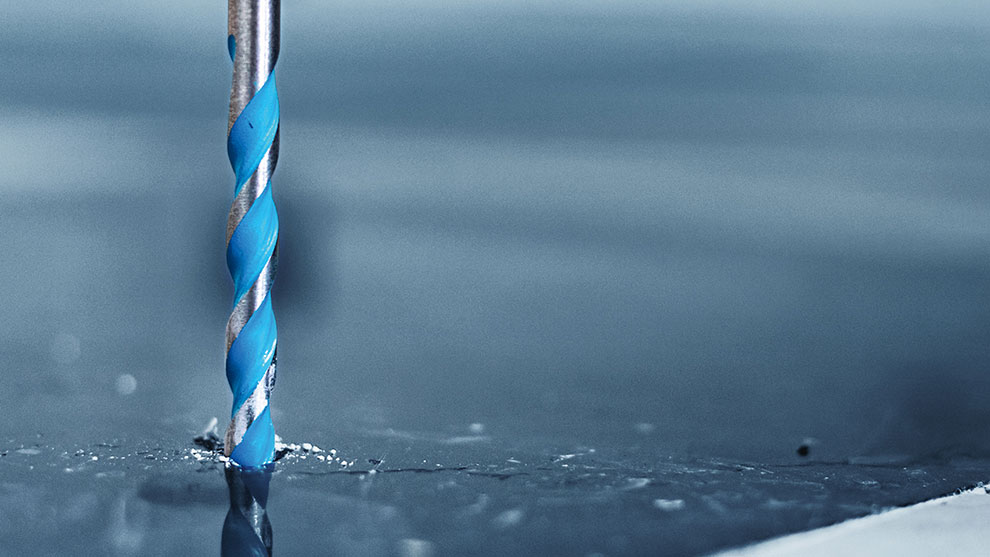 タイル 青いボッシュプロフェッショナルドリルが金属片の中で回転しています。