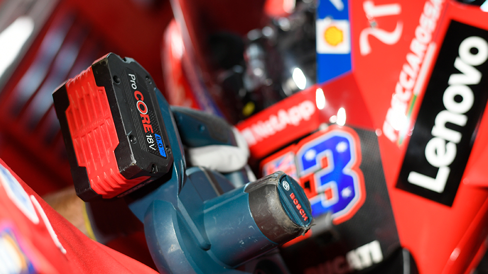 黒いハンドルの付いた赤いボッシュプロフェッショナルバッテリーが工具の上にあります。