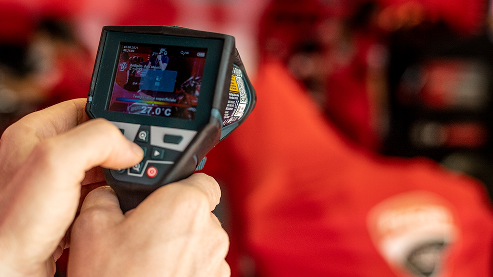 ある人が手にディスプレイ付きのデジタル温度計を持っています。