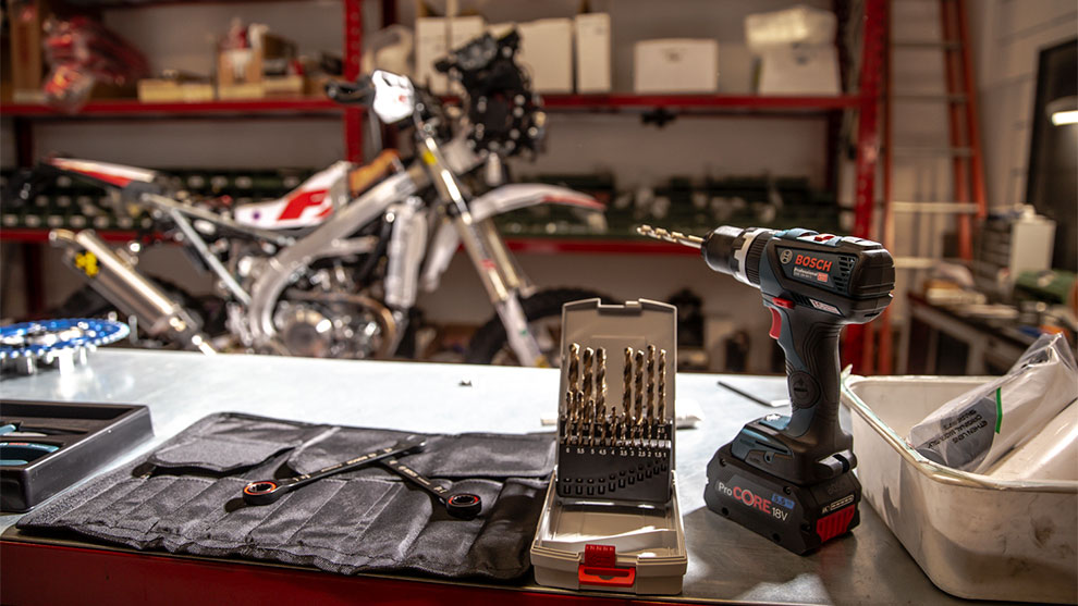 ボッシュプロフェッショナルのコードレスドライバーが工具の横にテーブルの上に置かれています。