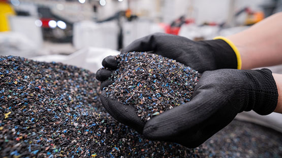 黒い手袋をした手がカラフルなプラスチック粒子を持っています.