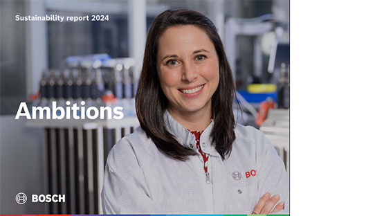 白いボッシュの白衣を着た笑顔の女性が機械の前に立っています。