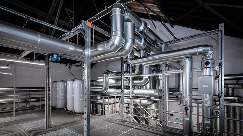 産業ビル内の銀色の配管と圧力容器。